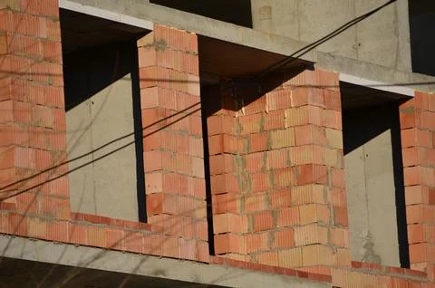 A brick wall with a window in the middle.  Stock Photos