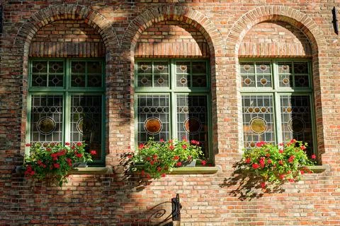 Brick windows and flower boxes on a historic Bruges facade in Belgium Stock Photos
