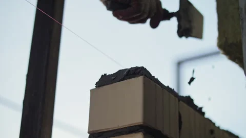 Bricklayer applying mortar on a brick during construction Stock Footage 300336713