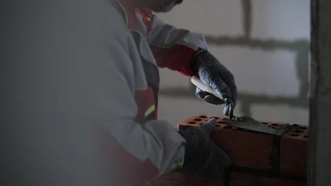 Bricklayer applying mortar to brick wall with trowel Stock Footage 323434393