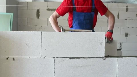 Bricklayer builder working with autoclaved aerated concrete blocks. Walling Stock Footage 88028182