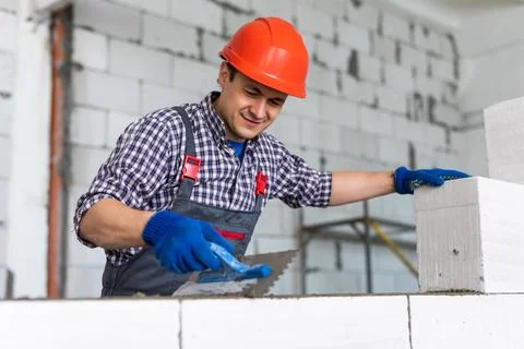 Bricklayer builder working with autoclaved aerated concrete blocks. Walling,  Stock Photos