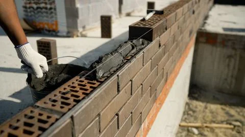 Bricklayer building a wall with mortar and bricks Stock Photos