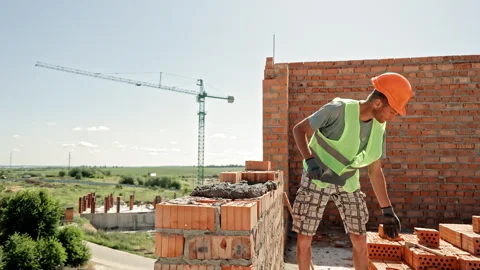 Bricklayer Builds Wall on Upper Floor Using Hollow Clay Bricks, Wearing Safety Video stock 312738716
