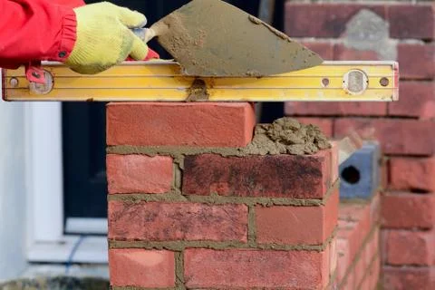 Bricklayer checking brick is level Stock Photos