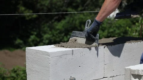 Bricklayer doing a cement layer for putting aerated concrete blocks. Stock-Footage 103127081