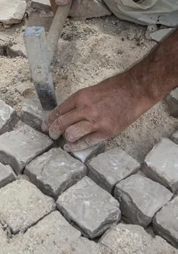 Bricklayer fixing portuguese pavement Stock Photos