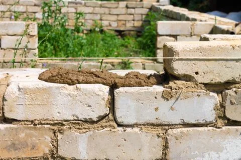 Bricklayer installs brickwork on the outside. Technology of cement masonry bu Stock Photos