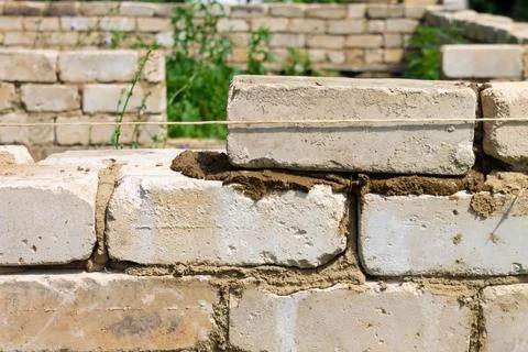 Bricklayer installs brickwork on the outside. Technology of cement masonry bu Stock Photos