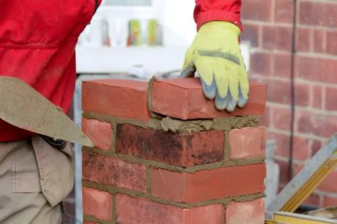 Bricklayer laying brick Stock Photos