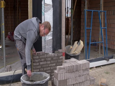 Bricklayer laying bricks at building site in Europe, medium shot 4K Stock Footage 75807241