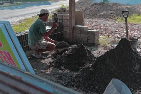 Bricklayer laying bricks at construction site in Lombok, Indonesia, 18 June.. Stock Photos