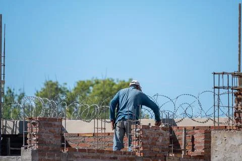 Bricklayer laying mud bricks in house construction in Argentina. Stock Photos