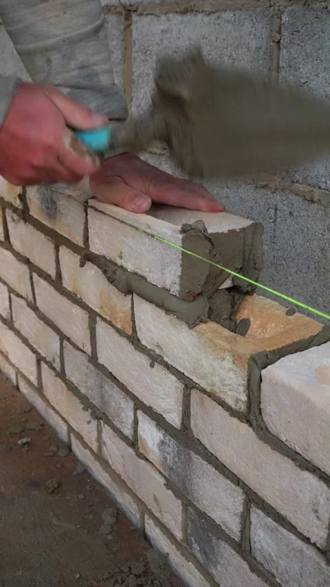Bricklayer Laying Precise Brickwork with Trowel and Guide Rope Stock Footage 327428453