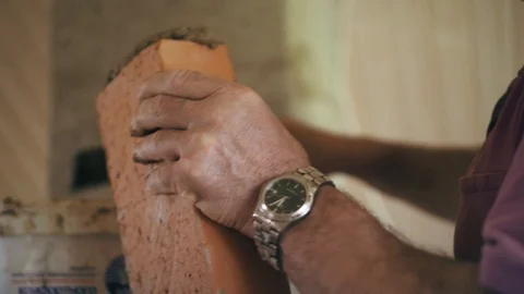 A bricklayer is laying red bricks with each other by a solution of cement Stock Footage 90090264