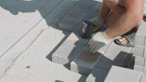 Bricklayer lays paving slabs. Close-up. Sound Stock Footage 145151784