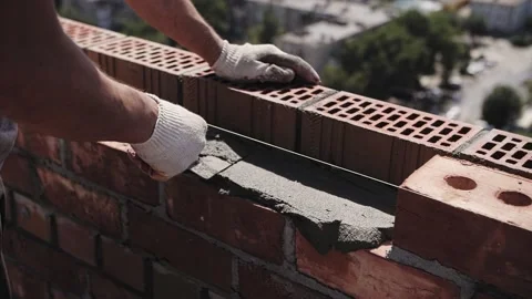 Bricklayer lays red brick, masonry wall Video stock 215723914
