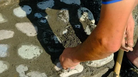 A bricklayer lays stones on a path. Stock Footage 134611320