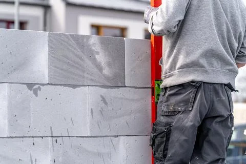 Bricklayer leveling bricks with the help of a spirit level during the 스톡 사진