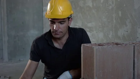 Bricklayer is looking at his mobile phone. Slow-motion Video stock 73362158
