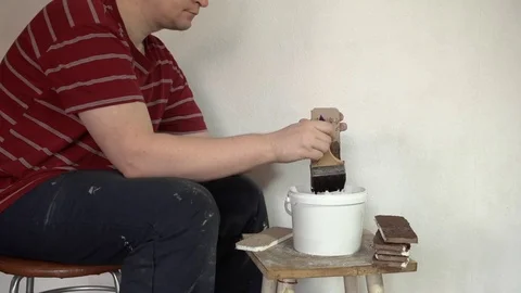 Bricklayer makes a decorative brick, covering the workpieces with liquid paint Stock Footage 75518261