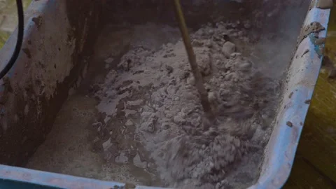 A bricklayer mixes plaster in a container using an electric construction mixer. Stock Footage 191591597