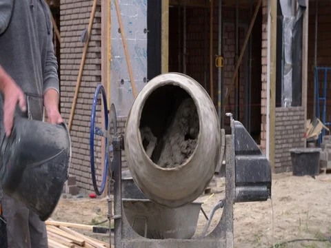 Bricklayer mixing mortar with cement mill at building site 4K Stock Footage 75807680