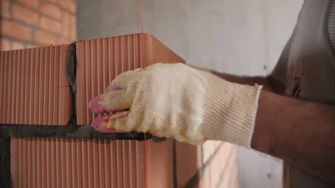 Bricklayer placing block using construction guideline string Stock Footage 311881819