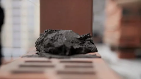 Bricklayer placing brick on mortar at construction site Stock Footage 315957927