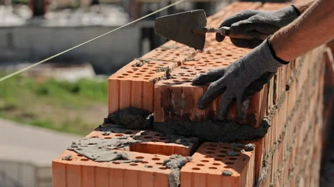 Bricklayer placing hollow brick with mortar. Close-up of a construction worker Stock Footage 316544275