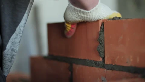 Bricklayer placing red clay bricks with mortar Stock Footage 318411768