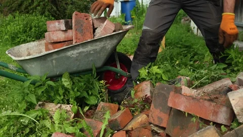A bricklayer puts bricks in a cart. Stock Footage 316496699
