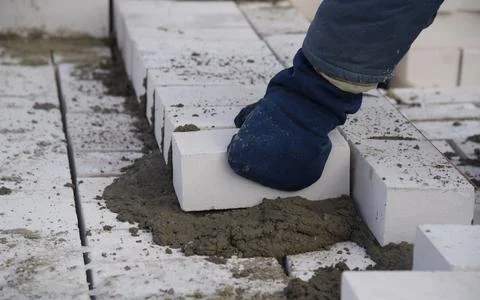 A bricklayer puts bricks in cement. 스톡 사진