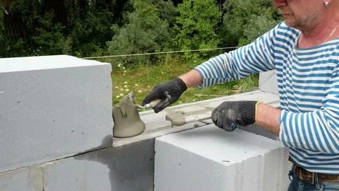Bricklayer putting down another row of bricks in site Stock Footage 113386663