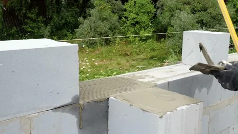 Bricklayer putting down another row of bricks in site Stock Footage 113387533