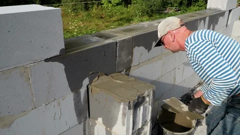 Bricklayer putting down another row of bricks in site Stock Footage 113387726