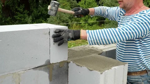Bricklayer putting down another row of bricks in site Stock Footage 113394149