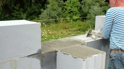 Bricklayer putting down another row of bricks in site Stock Footage 113397462