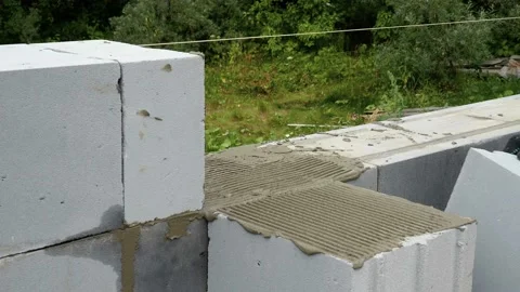 Bricklayer putting down another row of bricks in site Stock Footage 113397780