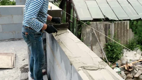 Bricklayer putting down another row of bricks in site Stock Footage 113398118