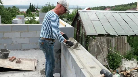 Bricklayer putting down another row of bricks in site Stock Footage 113398213