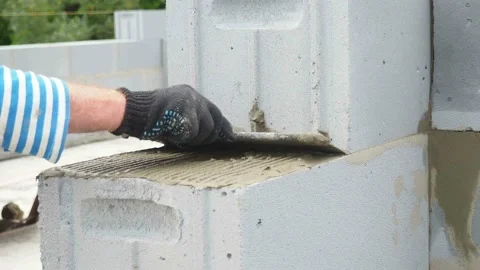 Bricklayer putting down another row of bricks in site Stock Footage 113398862