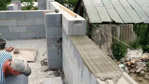 Bricklayer putting down another row of bricks in site Stock Footage 113399122