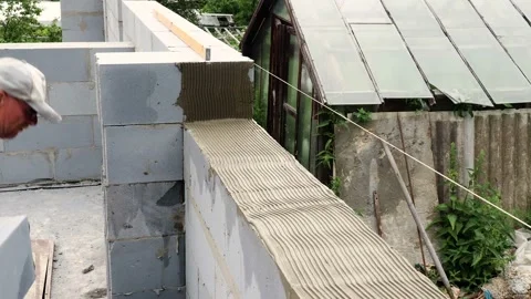 Bricklayer putting down another row of bricks in site Stock Footage 113399280