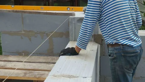 Bricklayer putting down another row of bricks in site Stock Footage 113400050