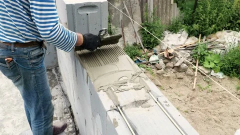 Bricklayer putting down another row of bricks in site Stock Footage 113400381
