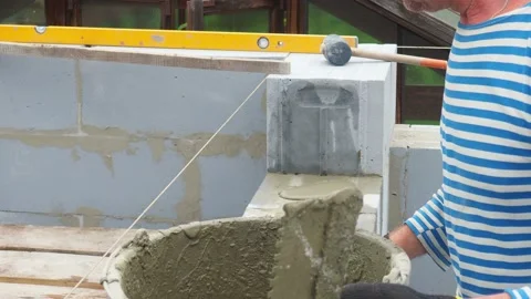 Bricklayer putting down another row of bricks in site Stock Footage 113401285