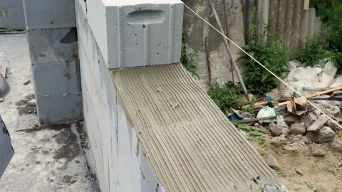 Bricklayer putting down another row of bricks in site Stock Footage 113401303