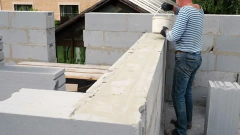 Bricklayer putting down another row of bricks in site Stock Footage 113401619