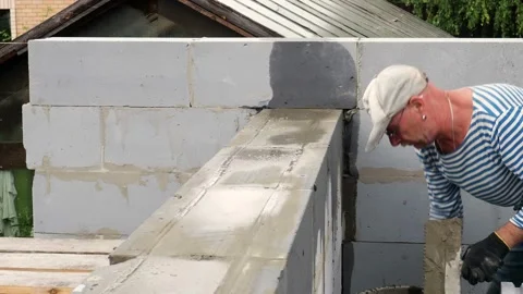 Bricklayer putting down another row of bricks in site Stock Footage 113402307